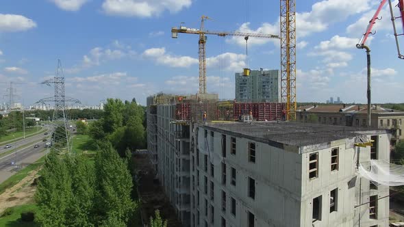 Aerial View of Unfinished Apartment House with Builders Working alt