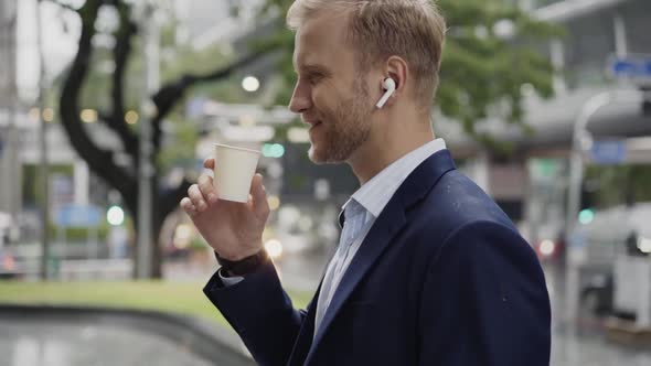 Businessman having phone call with earbuds, Bangkok, Thailand