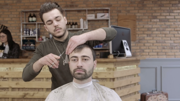 Man Hairdresser Doing Haircut Beard Adult Men in the Men's Hair Salon. Haircut with Scissors