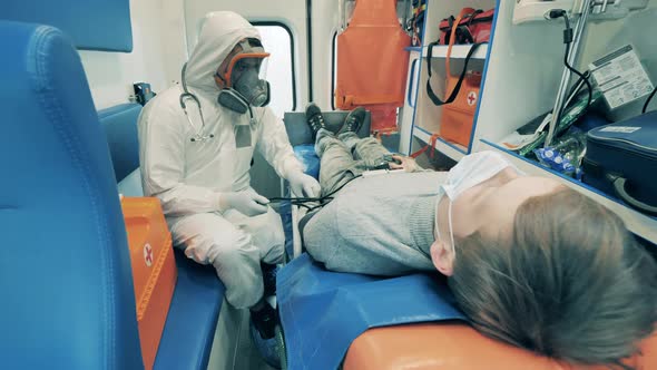 Ambulance Worker Measures Patient's Pressure in a Car