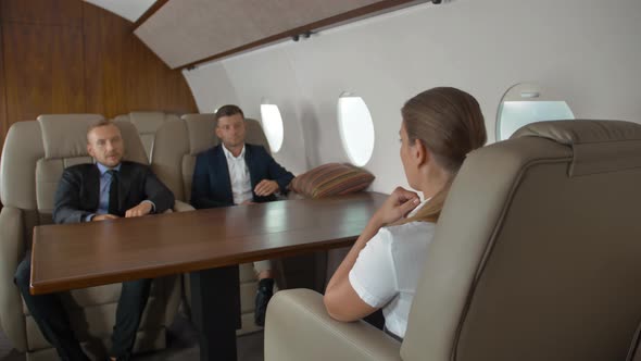 Two Confident Male Entrepreneurs and Successful Female Businesswoman Inside First Class Jet