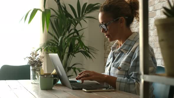 Woman working on laptop computer at home office workplace. Modern female people digital lifestyle.