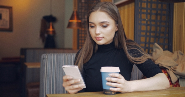 Pretty Girl Using Phone and Drinking Coffee