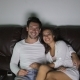 Couple Sitting On Couch Watching TV Program Embracing Talking, Young Man And Woman See Horror Movie - VideoHive Item for Sale