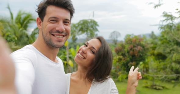 Couple Take Selfie Photo Embracing Outdoors Over Tropical Forest, Young Man And Woman Happy Smiling