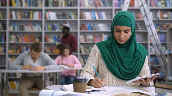 Pretty Muslim Female Student Learning in Library