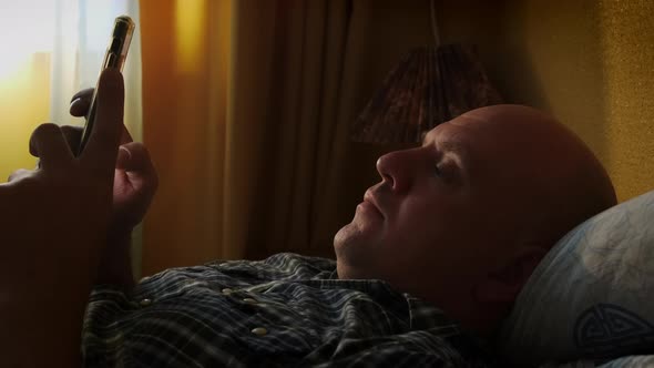 Man Chilling Lying in Bed with Smartphone