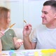Cute Daughter and Funny Dad Paint at the Table in Nursery - VideoHive Item for Sale