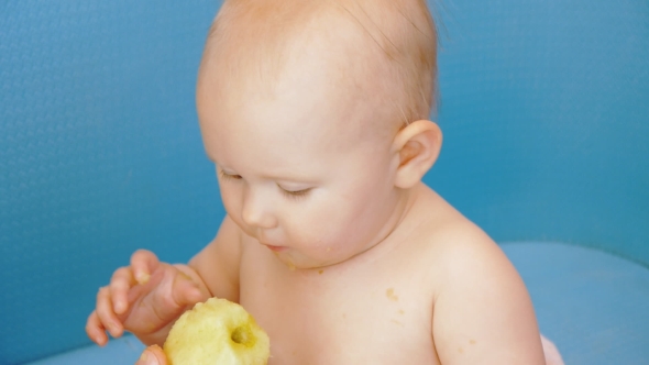 Baby Eats Peeled Apple Holding It in Both Hands