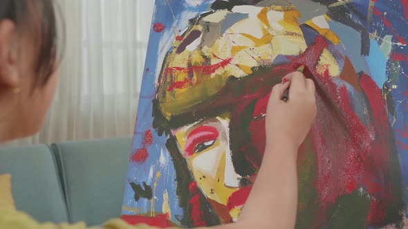 Close Up Of Asian Artist Girl Holding Paintbrush Painting A Girl's On The Canvas