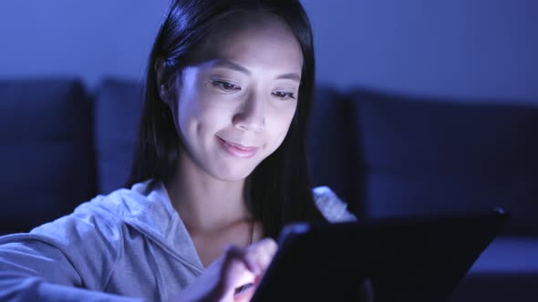 Woman using tablet computer at night 