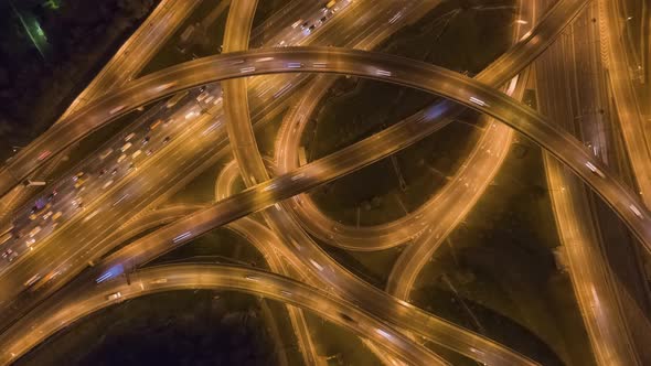 Road Intersection and Cars Traffic at Night. Flyover. Aerial Top Down View