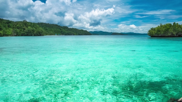 Beautiful Blue Lagoon with Pure Clear Water and Rainy Clouds in Background, Gam Island, West Papua