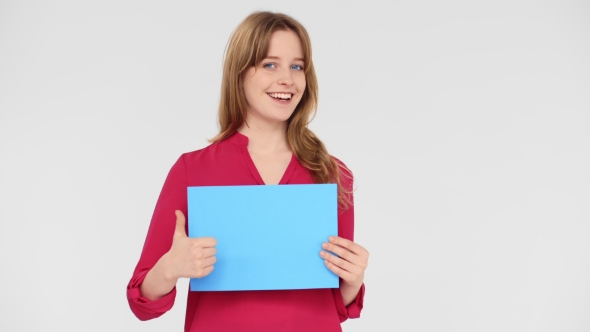 Charming Young Girl with Blue Eyes Standing on White Background and Shows the Sign and Thumb Up