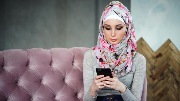 A Modern Arab Woman Communicates on Her Mobile Phone Online with Her Friends