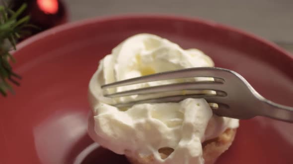 Fork and whipped cream topping over mince pie at Christmas