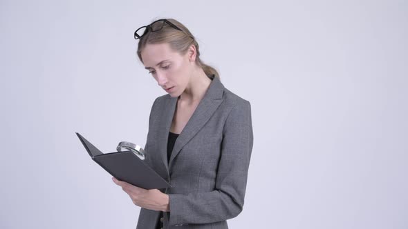 Young Blonde Businesswoman Reading Book Using Magnifying Glass