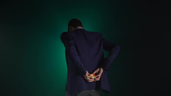 Clever Guy in Suit Is Solving Rubik's Cube in Dark.