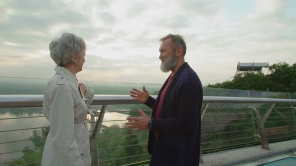 Mature Couple Standing on a Bridge Looking Together on City View