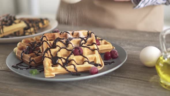 Sprinkle white icing sugar, baked Belgian waffles. Beautiful plate of homemade cakes Belgian waffles