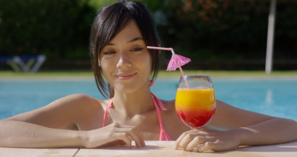 Woman Eyeing a Tropical Cocktail with Anticipation