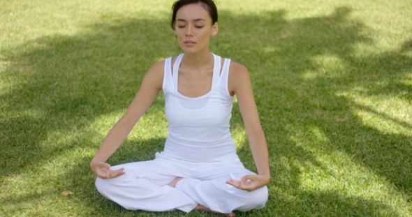 Pretty Serene Young Woman Meditating Outdoors