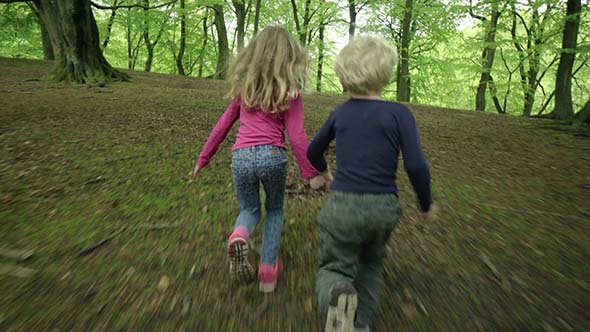 Brother And Sister Running In The Forest