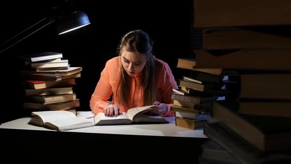 Girl Goes Through the Book and Find the Right Information. Black Background
