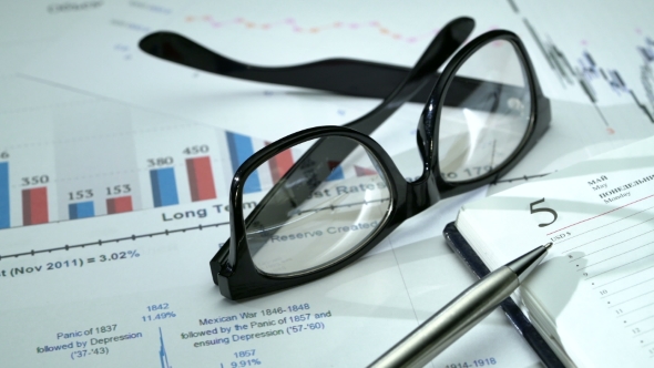 Office Desk with Business Graphics, Glasses, Pen and Notebook