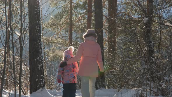 Little Girl with Mom Walking in Frosty Winter Day