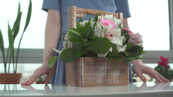 A Florist Girl Shows a Bouquet That Gathered Her Hands in a Wooden Basket