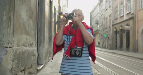 Senior Male Tourist Exploring Town and Makes a Photo with Photo Camera