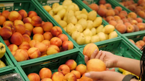 Closeup of a Young Woman Buying Fresh Fruit at a Grocery Store