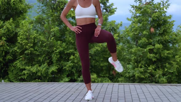 Fit Woman Doing Leg Rotation As Warmup Before Workout