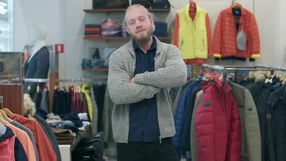 Confident Handsome Bearded Man Posing in Clothing Shop During Black Friday Sales. Portrait of