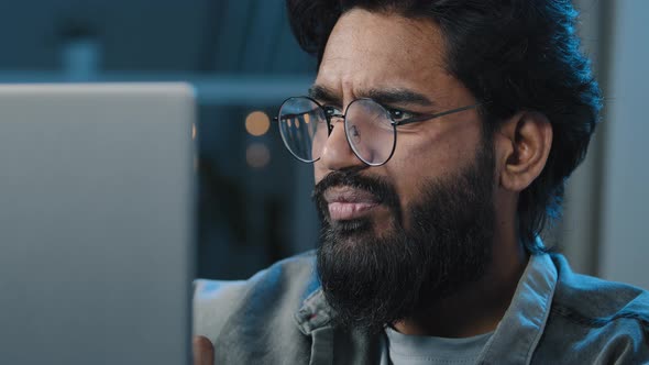 Close Up Arabian Indian Bearded 30s Man Freelancer User Wear Eyeglasses Looking at Computer Screen