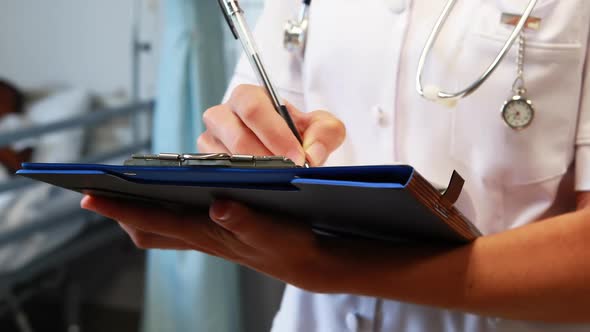 Female doctor writing on a clipboard