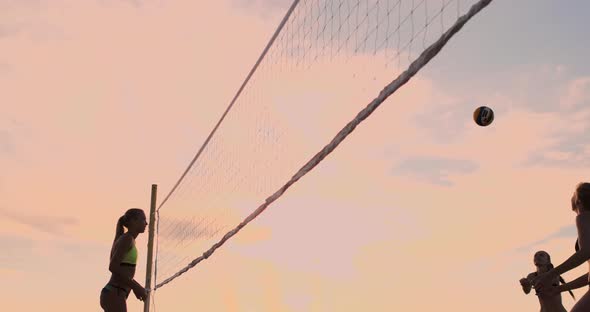 SLOW MOTION, LOW ANGLE, CLOSE UP, SUN FLARE: Athletic Girl Playing Beach Volleyball Jumps in the Air