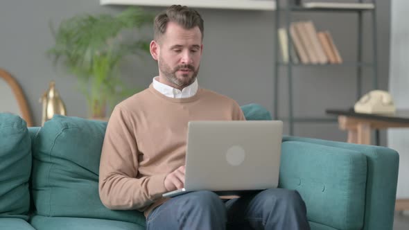 Man with Laptop Taking Nap on Sofa