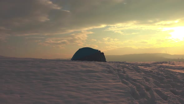 Hiker getting out from tent, enjoying cold weather