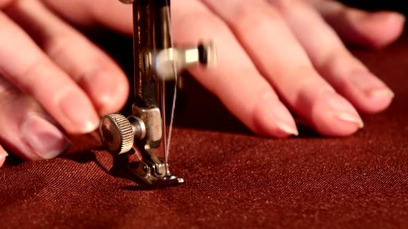 Woman's Hands Behind Her Sewing Process on Brown Tissue