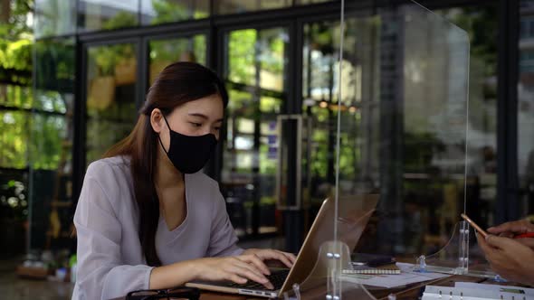 Asian Business Man and Woman Discussing in Coffee Shop with Masks on