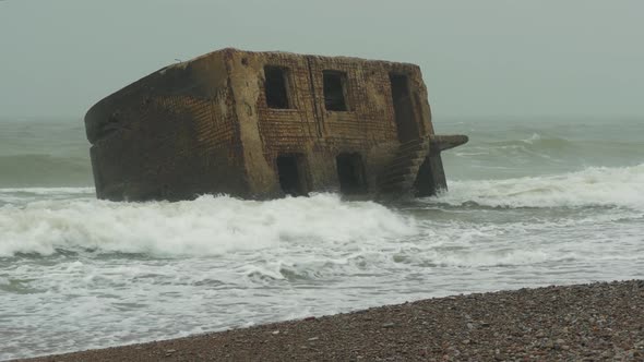 Big stormy waves breaking against abandoned seaside fortification building ruins at Karosta Northern