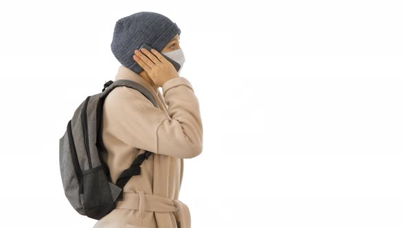 Woman Wearing Medical Mask Walking and Calling Someone One the Phone on White Background.