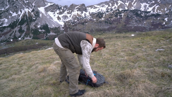 Hiker Going Along Grassy Slope