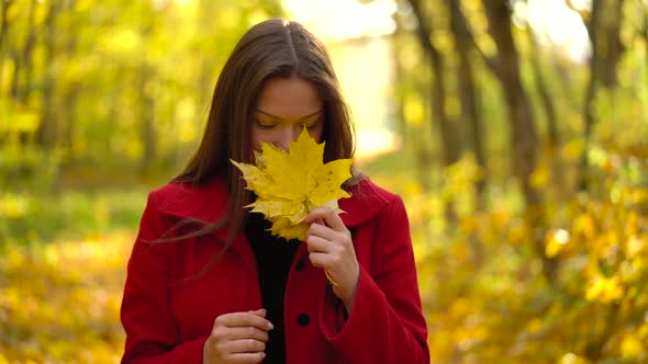 Beautiful Girl Walks in the Autumn Forest and Enjoys Good Weather