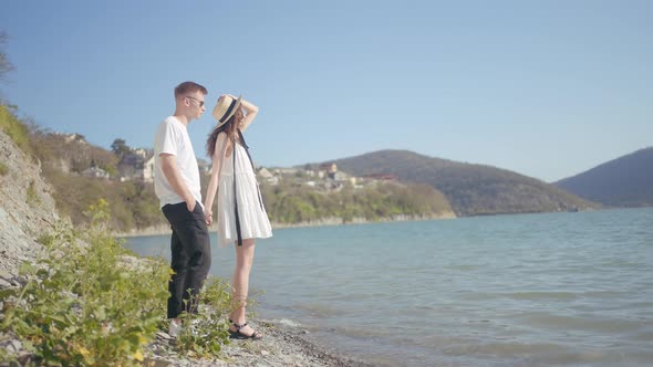 Side view of a couple standing on lake shore