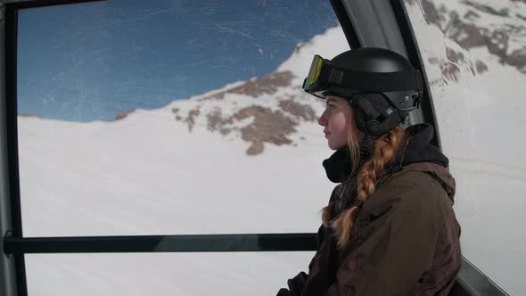 Young Woman With Red Plaits And Skiwear Travelling In Cable Car