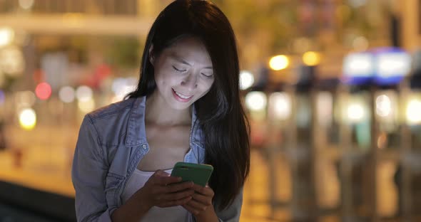 Woman using cellphone at night 