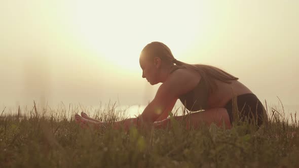 Sportswoman Stretches Against the Background of the Sea